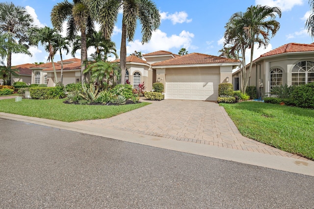 mediterranean / spanish-style home featuring a garage and a front lawn