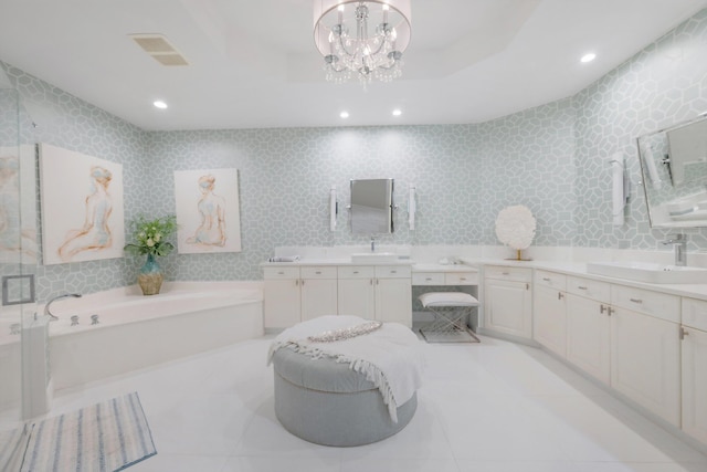 bathroom featuring vanity, a chandelier, and a bath