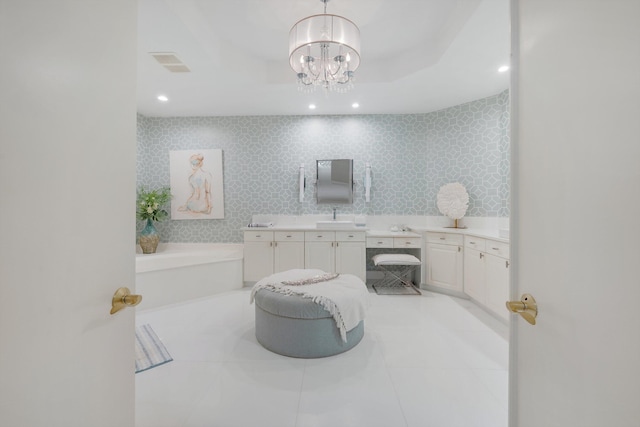 bathroom featuring vanity, a notable chandelier, and a bathing tub