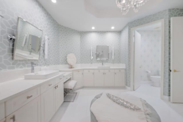 bathroom featuring vanity, a chandelier, and toilet