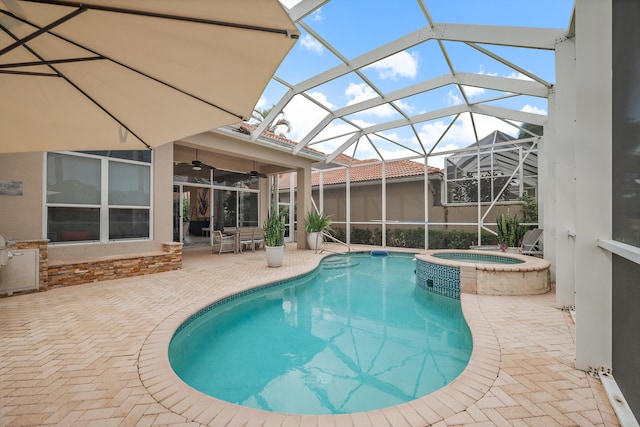 view of swimming pool featuring a patio, a lanai, an in ground hot tub, and ceiling fan