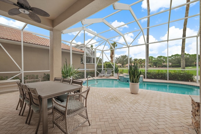 view of swimming pool featuring a patio area, glass enclosure, and ceiling fan