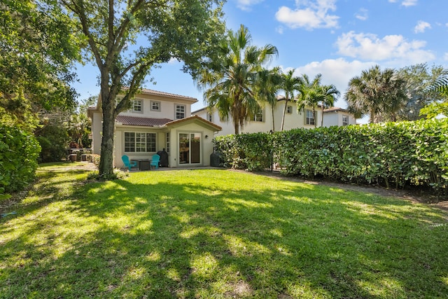 rear view of house featuring a yard and a patio area