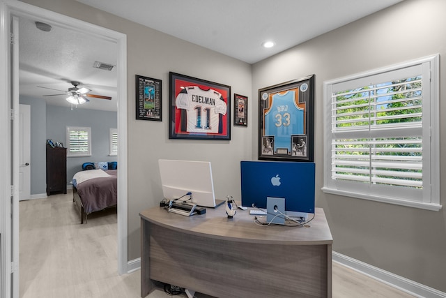 home office featuring light hardwood / wood-style floors and ceiling fan