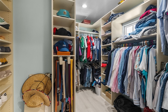 walk in closet with light hardwood / wood-style floors