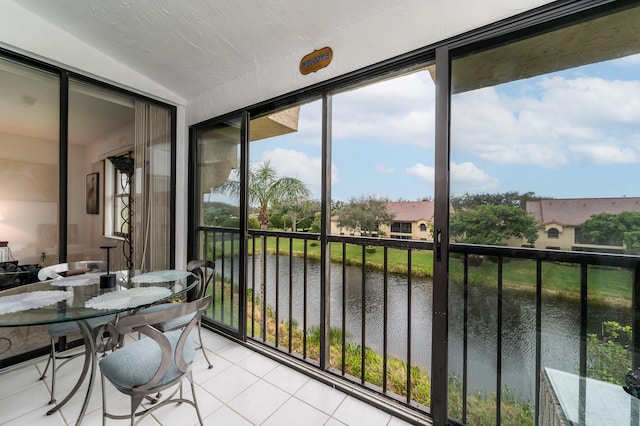 sunroom / solarium featuring a water view