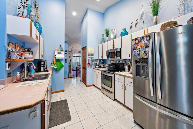 kitchen with white cabinetry, light tile patterned floors, stainless steel appliances, and sink