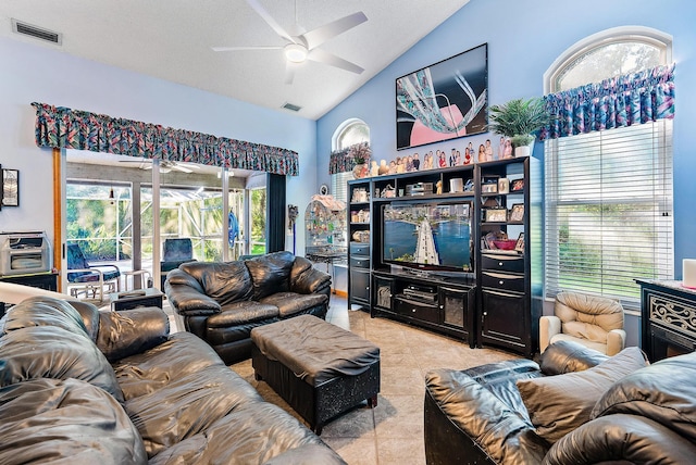 tiled living room featuring ceiling fan, a textured ceiling, lofted ceiling, and plenty of natural light