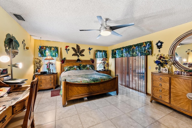 tiled bedroom featuring a textured ceiling and ceiling fan