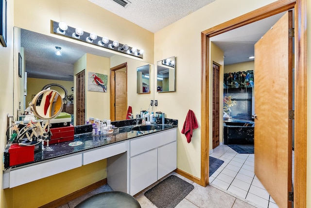 bathroom with vanity, a textured ceiling, and tile patterned flooring