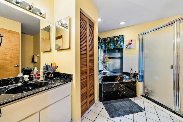 bathroom featuring vanity, shower with separate bathtub, and tile patterned floors