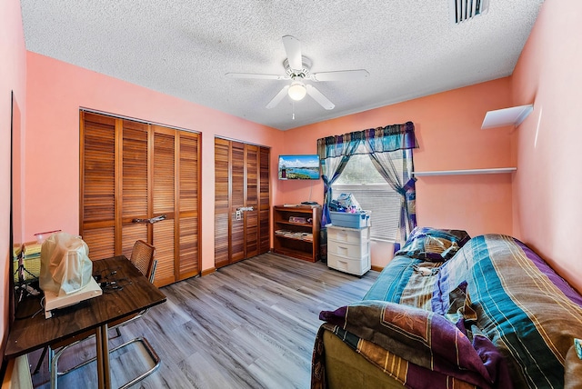 living area featuring light hardwood / wood-style flooring, a textured ceiling, and ceiling fan