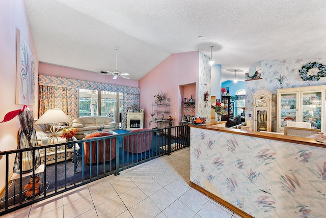 kitchen with lofted ceiling, a textured ceiling, ceiling fan, and light tile patterned floors