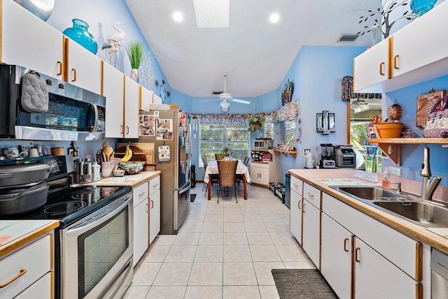 kitchen with white cabinets, light tile patterned floors, ceiling fan, white electric stove, and sink