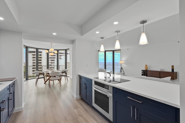 kitchen featuring blue cabinetry, black electric stovetop, decorative light fixtures, and oven