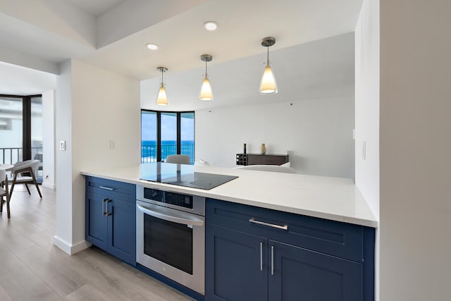 kitchen with blue cabinetry, light hardwood / wood-style flooring, pendant lighting, black electric stovetop, and oven