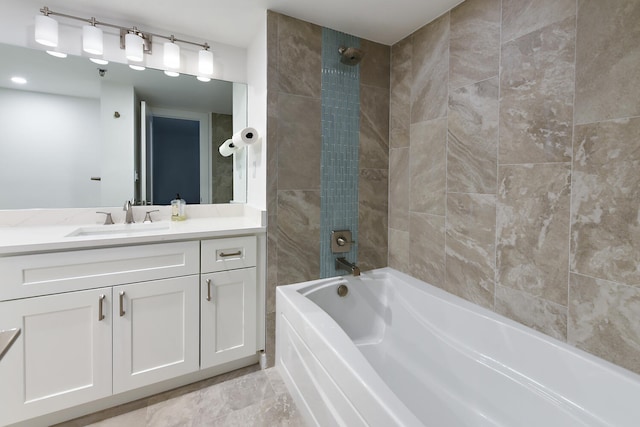 bathroom featuring tiled shower / bath combo and vanity