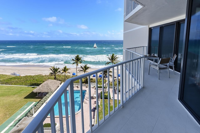 balcony with a water view and a beach view