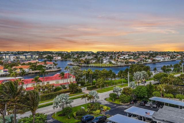 aerial view at dusk featuring a water view