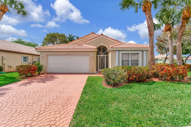 mediterranean / spanish-style house featuring a garage and a front lawn