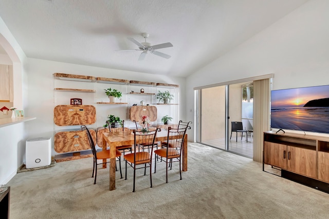 dining area with ceiling fan, lofted ceiling, and light colored carpet