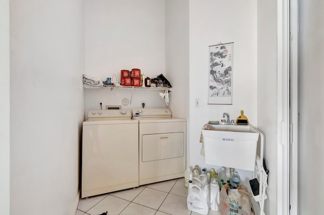 washroom featuring washer and dryer, light tile patterned flooring, and sink