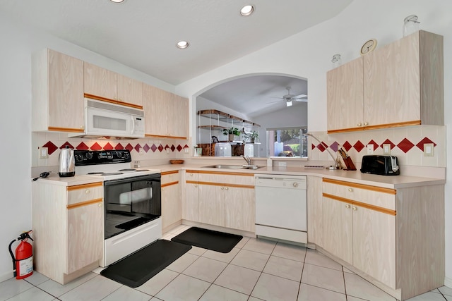 kitchen featuring light brown cabinetry, sink, vaulted ceiling, and white appliances