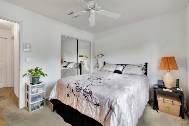 carpeted bedroom featuring a closet and ceiling fan