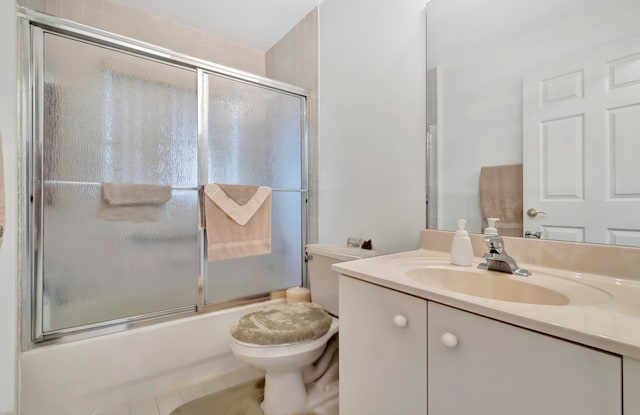 full bathroom with vanity, toilet, tile patterned floors, and shower / bath combination with glass door