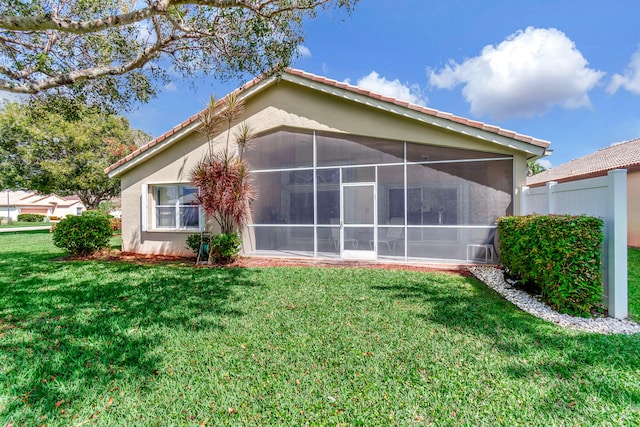 rear view of property with a yard and a sunroom