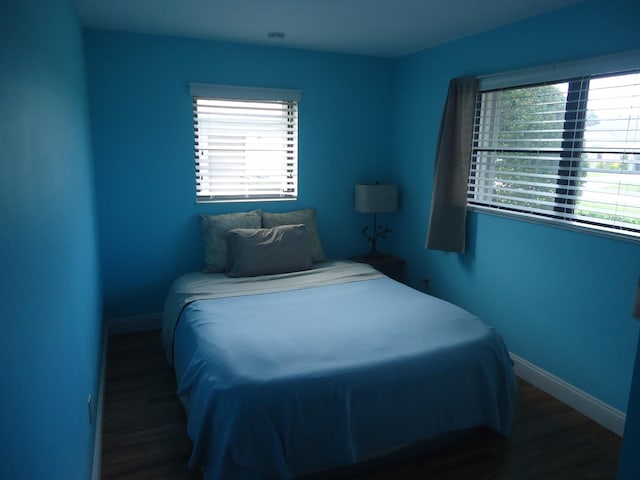 bedroom with dark hardwood / wood-style flooring