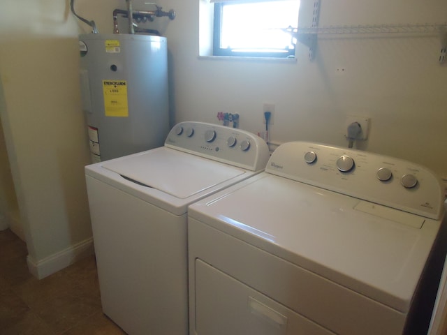 laundry room with electric water heater, washer and dryer, and tile patterned flooring