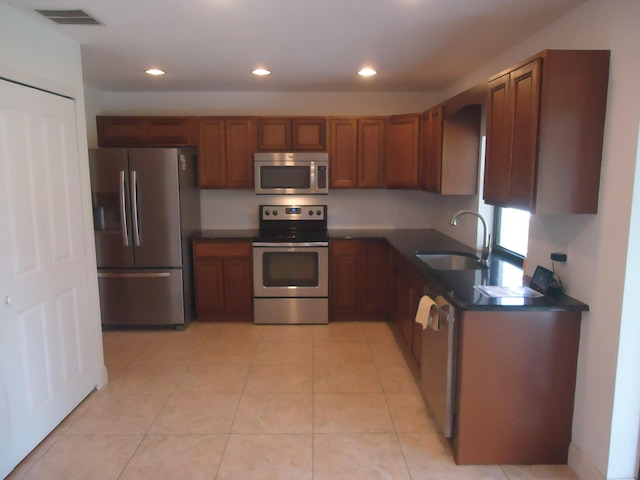 kitchen featuring appliances with stainless steel finishes, sink, and light tile patterned floors