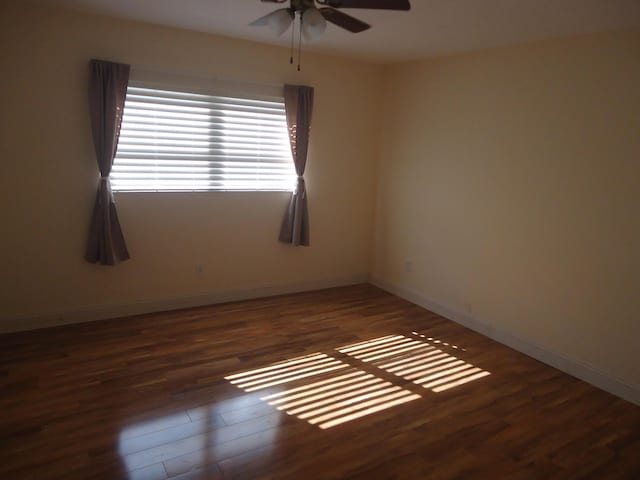 empty room featuring ceiling fan and dark hardwood / wood-style floors