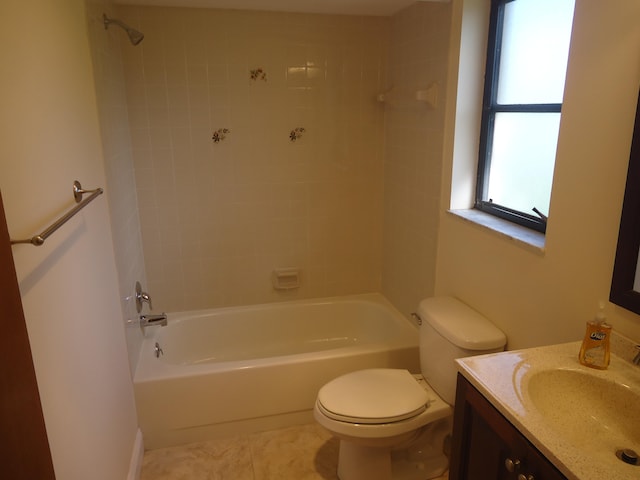 full bathroom featuring tile patterned flooring, vanity, tiled shower / bath combo, and toilet