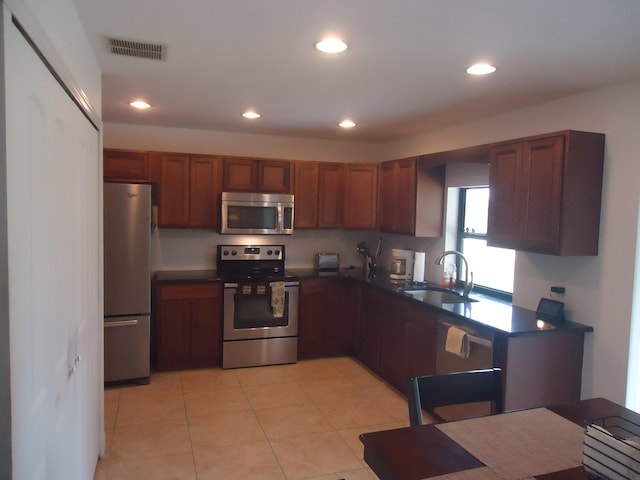 kitchen featuring appliances with stainless steel finishes, sink, and light tile patterned flooring