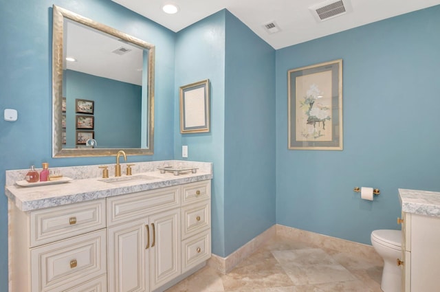 bathroom with toilet, vanity, and tile patterned floors