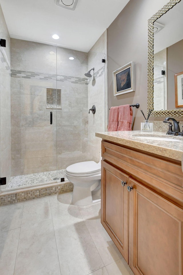 bathroom with vanity, toilet, walk in shower, and tile patterned flooring