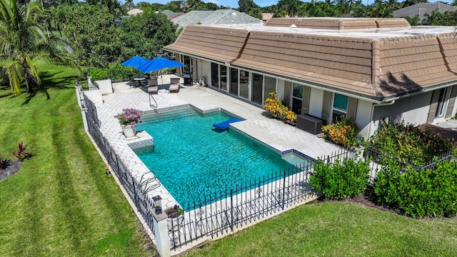 view of pool with a patio area and a lawn