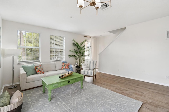 living area featuring visible vents, wood finished floors, a wealth of natural light, and baseboards