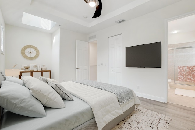 bedroom with light wood-style flooring, a skylight, visible vents, baseboards, and a closet