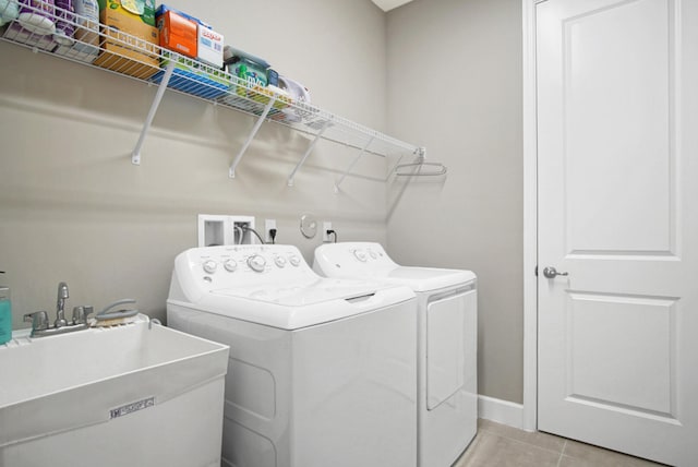 laundry room featuring sink, washing machine and dryer, and light tile patterned floors