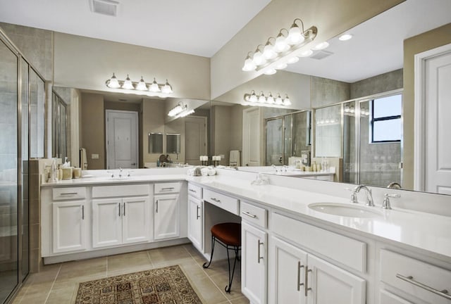 bathroom featuring a sink, tile patterned flooring, a stall shower, and visible vents
