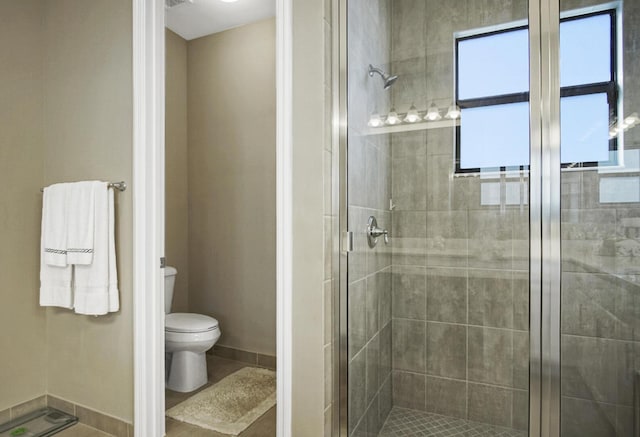 bathroom featuring a stall shower and toilet