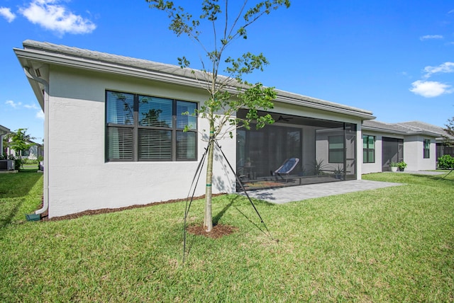 rear view of house with a patio, a sunroom, a lawn, and central air condition unit