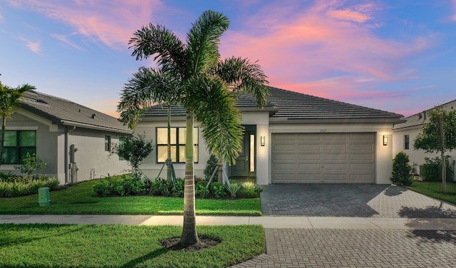 view of front of home featuring a garage and a lawn