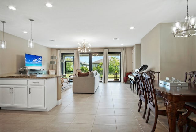 interior space featuring white cabinetry, decorative light fixtures, sink, and dark stone counters