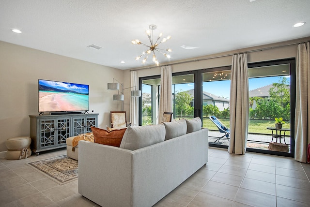 tiled living room featuring a wealth of natural light, a notable chandelier, and a textured ceiling