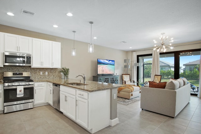 kitchen with kitchen peninsula, stainless steel appliances, sink, pendant lighting, and white cabinets