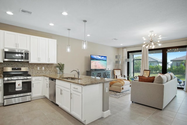 kitchen featuring visible vents, a sink, open floor plan, and stainless steel appliances